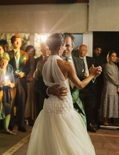 a bride and groom dance together in front of their guests at a wedding reception with sparklers