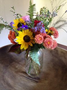 a vase filled with flowers sitting on top of a wooden table