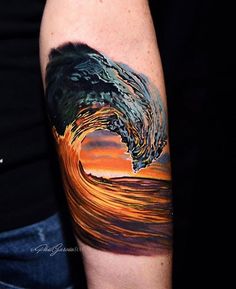 a man's arm with a colorful wave tattoo on it