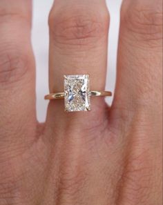 a woman's hand with a diamond ring on top of her finger and an engagement band