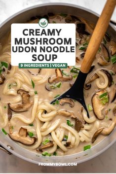 creamy mushroom udon noodle soup in a pot with a wooden spoon on the side