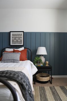 a bed room with a neatly made bed next to a night stand and two lamps