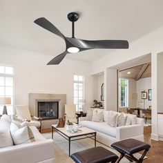 a living room filled with furniture and a ceiling fan in the middle of the room