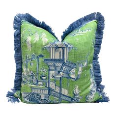 a green pillow with blue tassels and a birdhouse on the front side