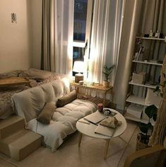 a living room filled with furniture next to a window covered in white curtains and drapes