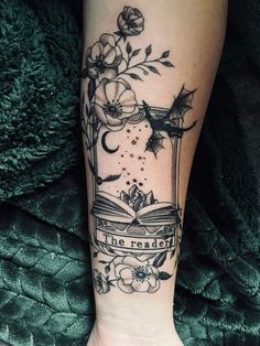 a woman's leg with a book and flowers on it, reading the reader