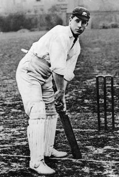 an old black and white photo of a man holding a bat in front of a ball