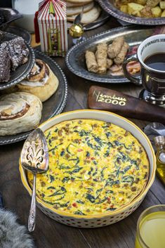 a table full of food and drinks on it's sides, including breads, pastries, and muffins