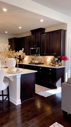 a kitchen with dark wood cabinets and white counter tops is pictured in this image from the living room