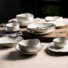 a table topped with lots of white dishes