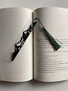 an open book with a tassel hanging from it's cover and the pages are black