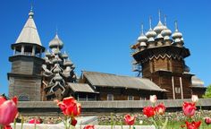 some red and white tulips in front of an old wooden building with spires