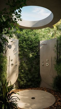 an outdoor shower in the middle of a lush green area with trees and plants around it