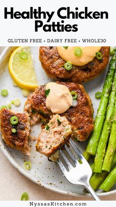 healthy chicken patties on a plate with asparagus, lemon wedges and mayonnaise