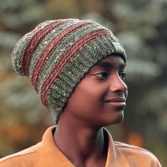 a close up of a person wearing a knitted hat and looking off to the side