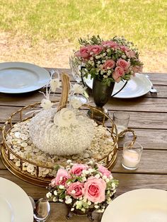 the table is set with flowers and plates on it, along with a basket full of rice