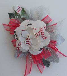 a baseball themed corsage with red and white ribbons