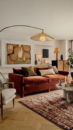 a living room filled with furniture and a large painting on the wall above it's fireplace