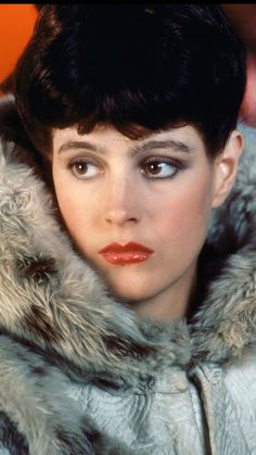 a woman wearing a fur coat and red lipstick