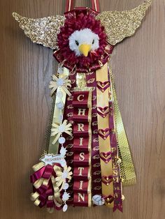 an eagle made out of ribbons and other items on a wooden surface with gold glitters