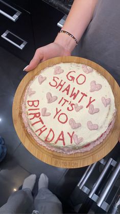 a person holding a birthday cake with the words go shanty it's to birthday written on it