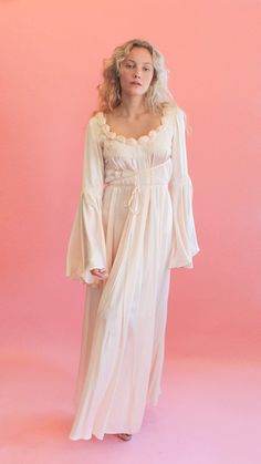 Delicate as a rose, this embroidered silk gown will make you feel pretty in pink. The bell sleeves on this piece are absolutely incredible and flow beautifully with movement. Style this dress for a spring party with a pair of strappy sandals and dainty gold earrings for a fresh look. The dress is meant to be tied as pictured, but the bust ties can be tied however you please. The gown has no closure, it slips on overhead.The gown is in excellent vintage condition. Please see measurements to confi White Cut Out Dress, White Satin Dress, Dainty Gold Earrings, Spring Party, Silk Gown, Feel Pretty, Fresh Look, Lace White Dress, Historical Clothing