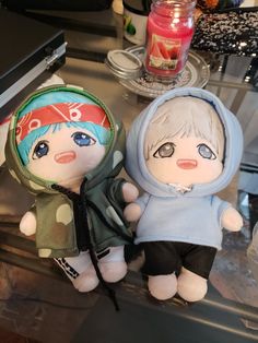 two stuffed dolls sitting next to each other on a table