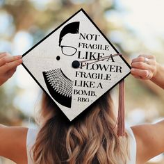 a woman wearing a graduation cap that says not fragile like a flower fragile like a bomb