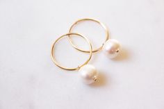 "Classic, minimalist, everyday, trendy earrings. DESIGN: Dangling / Hoops / Drops MATERIALS: Metal: 14k Goldfilled Stone: Freshwater Pearl DETAILS: Earring Type: Hoops Shape: Potato, Round Dimension of the Pearl: 7 - 8 mm Height: approx 11 mm Diameter of the Hoops: 20 mm Total Length: approx 31 mm Please take note that any stones and pearls are naturally imperfect. ------------------------------------------------------------------------------------------------------------------------------------ Minimalist White Hoop Earrings For Anniversary, Simple 14k Gold-filled Round Earrings, Simple 14k Gold Filled Round Earrings, Simple 14k Gold Filled Earrings, Simple Round 14k Gold Filled Earrings, Minimalist White Hoop Earrings For Everyday, Minimalist Pearl Huggie Earrings, Everyday Yellow Gold Pearl Earrings, Minimalist Small Hoop Pearl Earrings Gift