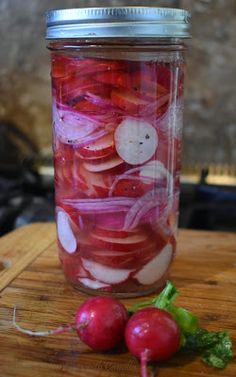 a jar filled with pickled onions and radishes