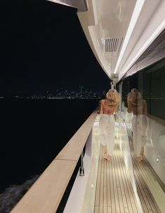 two women are on the deck of a boat at night