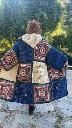 a woman is walking down the street wearing a blue and yellow jacket with circles on it