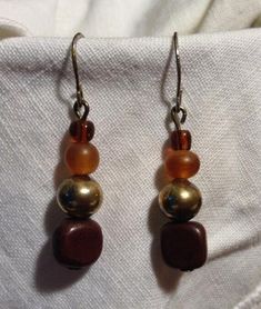 These earrings are beautiful!!  They are golden glass beads with antique silver and brown wood beads hanging from ear wires. Brown Nickel-free Dangle Beaded Earrings, Nickel-free Brown Beaded Dangle Earrings, Brown Copper Bead Earrings, Brown Copper Earrings With Round Beads, Vintage Brown Earrings With Dangling Beads, Vintage Brown Beaded Earrings For Gift, Vintage Brown Beaded Earrings As Gift, Gold Bohemian Earrings With Wooden Beads, Vintage Brown Round Bead Earrings