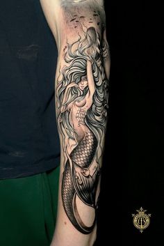 a woman with a mermaid tattoo on her arm