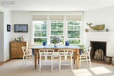 a dining room table with four chairs and a fire place in the corner next to it