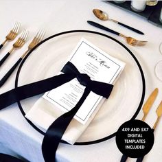 the table is set with black and white place settings, silverware, and napkins