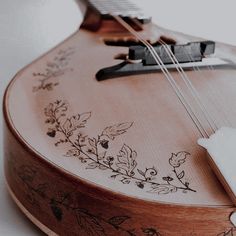 a close up of a wooden guitar with flowers on it