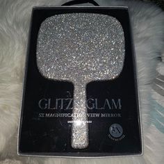 the box is open and has a silver glitter hair brush in it's packaging