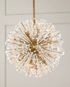 a chandelier hanging from the ceiling in front of a door with white walls