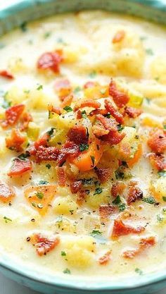 a blue bowl filled with potato soup on top of a table