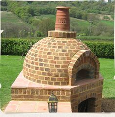 an outdoor brick pizza oven in the grass