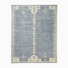 a blue and beige rug with an intricate design on the bottom, in front of a white background