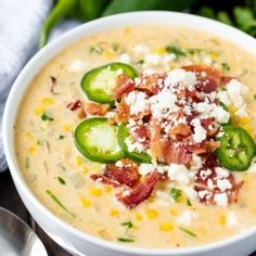 a white bowl filled with soup and topped with bacon, cheese and jalapenos