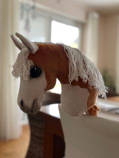 a stuffed horse is sticking its head over the edge of a table