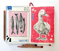 an open notebook with two drawings of fish and a duck on the cover, next to colored pencils