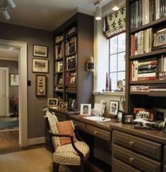 a chair sitting in front of a desk with pictures on it and bookshelves