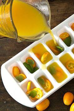 an ice tray filled with oranges and juice