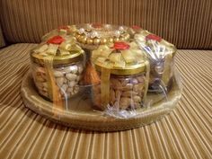 three glass jars filled with nuts on top of a wooden table next to a couch