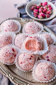 several desserts are on a silver platter and one is filled with powdered sugar