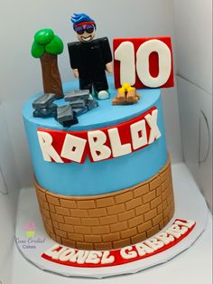 a birthday cake with a person on top and the name robblox written in red